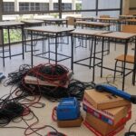 Sala de aula em escola de Brasília com equipamentos de robótica desorganizados, ilustrando lei sem planejamento aprovada pela CLDF.