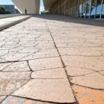 Calçada irregular em Brasília destacando falhas crônicas na acessibilidade para deficientes no DF.