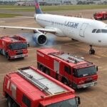 Avião da Latam em pouso de emergência no aeroporto de Ribeirão Preto após explosão de bateria, com veículos de emergência ao redor.