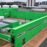 Instalação de hidrogênio de baixa emissão em Brasília, com Congresso Nacional ao fundo, destacando lei tardia e críticas por ineficácia.