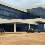 Sede da Polícia Federal em Brasília com viaturas, representando ordem ignorada por Eduardo Bolsonaro nos EUA.