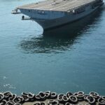 Navio militar americano USS Iwo Jima com algemas no deck, próximo à costa brasileira, representando foto divulgada por Trump de Maduro algemado.