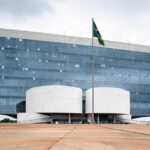 Edifício do TJDFT em Brasília com bandeira a meio mastro, simbolizando luto pela morte de desembargador.