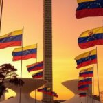 Torre de TV em Brasília com bandeiras venezuelanas, representando celebração de exilados pela prisão de Maduro.