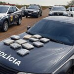 Viaturas policiais na divisa DF-Goiás com tabletes de drogas apreendidos em operação contra tráfico.