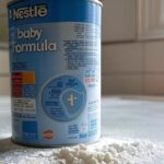 Lata aberta de fórmula infantil contaminada da Nestlé derramada sobre mesa em casa no DF, Brasil.