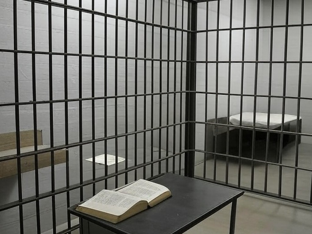 Cela de prisão brasileira com Bíblia e cruz, sem Smart TV, em estilo fotojornalístico.