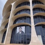 Fachada da CLDF em Brasília com banner vazio, ilustrando frustração por anúncio vago de concurso fotográfico.