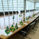 Sala de reuniões com bandeiras de estados brasileiros e documentos de reforma tributária em Brasília.