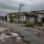 Rua abandonada em Nova Colina, DF, com sinais de descaso e deterioração urbana.