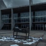 Fachada da CLDF em Brasília com berço vazio e documentos espalhados, simbolizando suporte pós-parto e falhas no sistema de saúde.