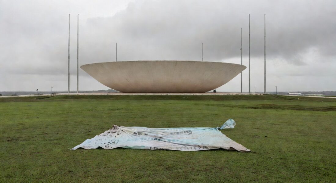 Edifício da CLDF em Brasília com cartaz dos 60 anos do CRO-DF caído, representando demandas ignoradas de odontólogos.