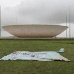 Edifício da CLDF em Brasília com cartaz dos 60 anos do CRO-DF caído, representando demandas ignoradas de odontólogos.