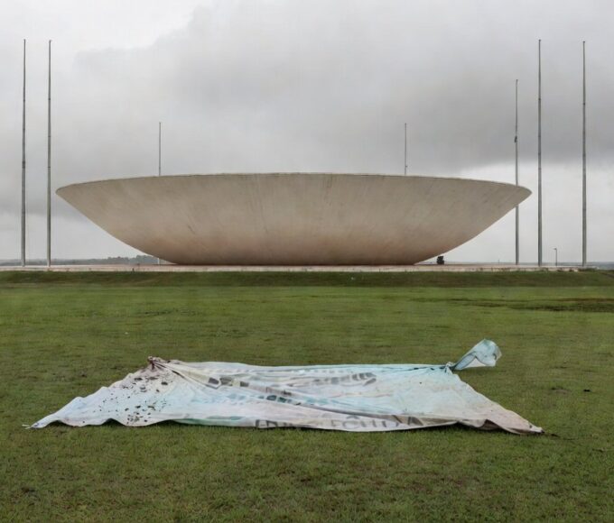 Edifício da CLDF em Brasília com cartaz dos 60 anos do CRO-DF caído, representando demandas ignoradas de odontólogos.