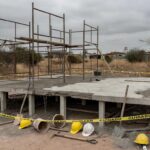 Obra de construção no Gama, DF, com laje de concreto e equipamentos de segurança, representando acidente fatal.