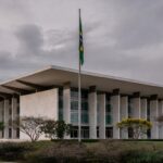 Fachada do TJDFT em Brasília com bandeira a meio mastro, simbolizando luto pela morte da desembargadora Maria de Lourdes Abreu.