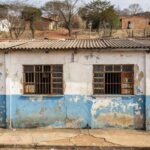 Escola antiga em Sobradinho com fachada desgastada, representando homenagem aos 60 anos e críticas ao sistema educacional no DF.