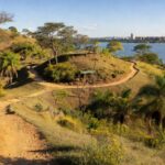 Paisagem da Serrinha do Paranoá no DF, com vegetação do Cerrado e vista do lago, representando transformação em parque ambiental.