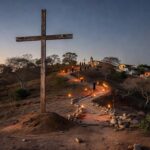Encenação da Via-Sacra em Planaltina com cruz de madeira em colina ao entardecer, elementos religiosos simbólicos.