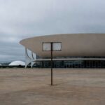 Prédio da Câmara Legislativa em Brasília com elementos de exclusão etária, representando projeto de reinserção de idosos no DF.