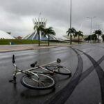Cena de acidente de trânsito em rua de Brasília com bicicleta caída e marcas de pneus, representando atropelamento fatal de ciclista no DF.