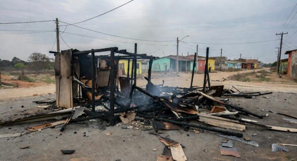 Barraco carbonizado após incêndio em Ceilândia, com cinzas e fumaça residual em rua periférica.