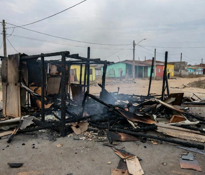 Barraco carbonizado após incêndio em Ceilândia, com cinzas e fumaça residual em rua periférica.