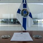Mesa com decreto de promoções na PMDF e CBMDF em escritório governamental de Brasília.