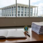 Mesa com decreto e contratos no escritório governamental do DF, representando contenção de gastos e revisão de contratos pela governadora Celina Leão.